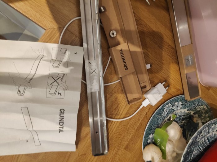 Ikea Grundtal magnetisk knivupphängare och monteringsanvisning på träbord, oöppnad förpackning.