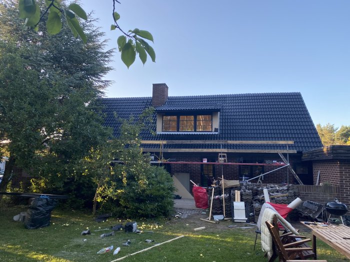 Renoverat hus med nylagt svart tegeltak, gavelpannor kapade på kupan, utan synliga plåtar.