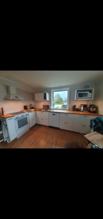 Renoverat kök med vita skåp och utan synlig utsugskanal, och funderingar kring installation av kolfilterfläkt.