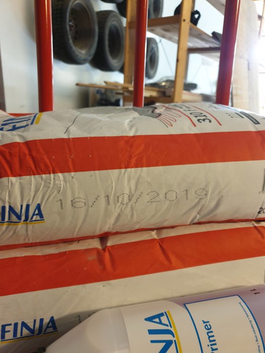 Säckar med Finja 310 F spackel och datumstämpel 16/10/2019 synliga på förpackningen.