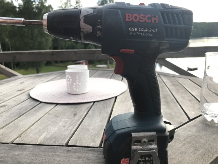 Bosch GSR 14,4-2-LI skruvdragare på ett trädäck med kaffekopp och tallrik i bakgrunden.