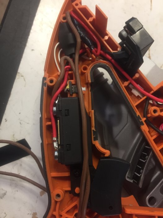 Interiör av en isärtagen såg med synlig brytare och elanslutningar.