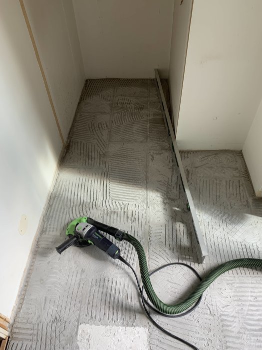 Renoveringsprojekt i hall med borttagna garderobsdörrar, synlig klinkersborttagning och verktyg.