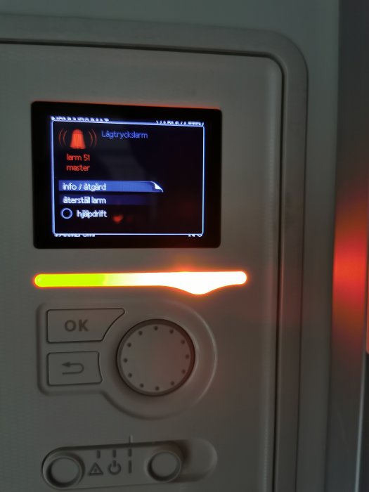 Digital panel på värmepump med larm för lågtrycksalarm och rött lysande varningsljus.