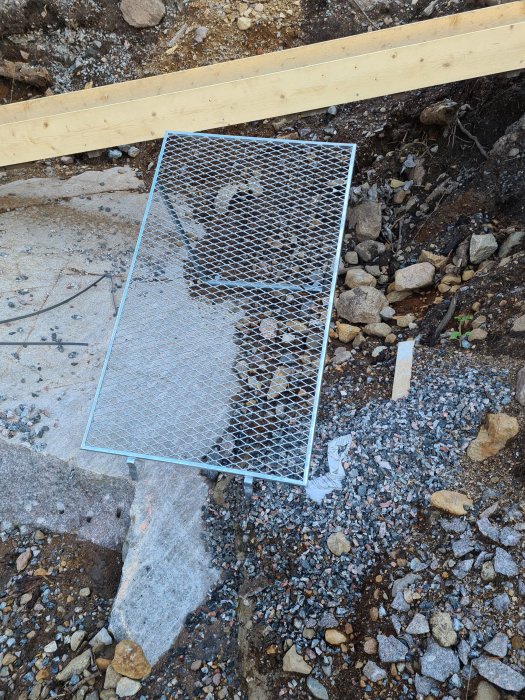 Harpa med stora maskhål placerad på grus vid en byggplats, olämplig för 8-12 kross.
