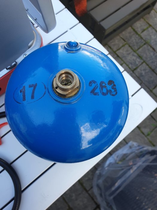 Blå, rund byggnadskomponent med siffrorna "17" och "263" och en central öppning, placerad på vit yta.