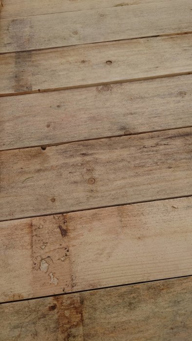 Gammal träpanel med möjliga svartmögel fläckar och lager av smuts och missfärgningar.