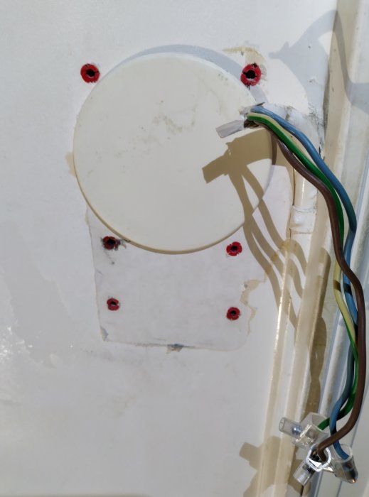 Vägg med avlägsnat eluttag som visar fyra elektriska ledningar och bar väggyta.