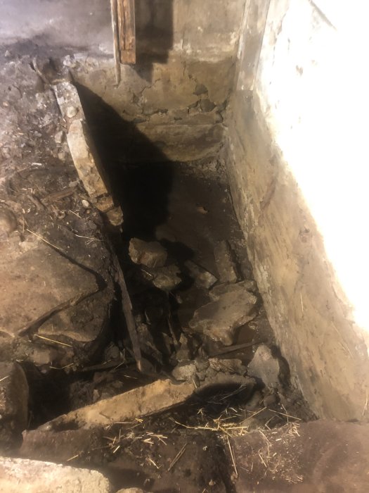 Sprucken betong och skadad lättbetongvägg i en gammal ladugårdsbyggnad som omvandlats till verkstad.