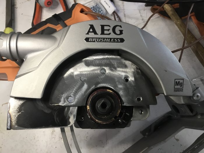 Delvis isärmonterad AEG 18v vinkelslip med fokus på det modifierade sprängskyddet.