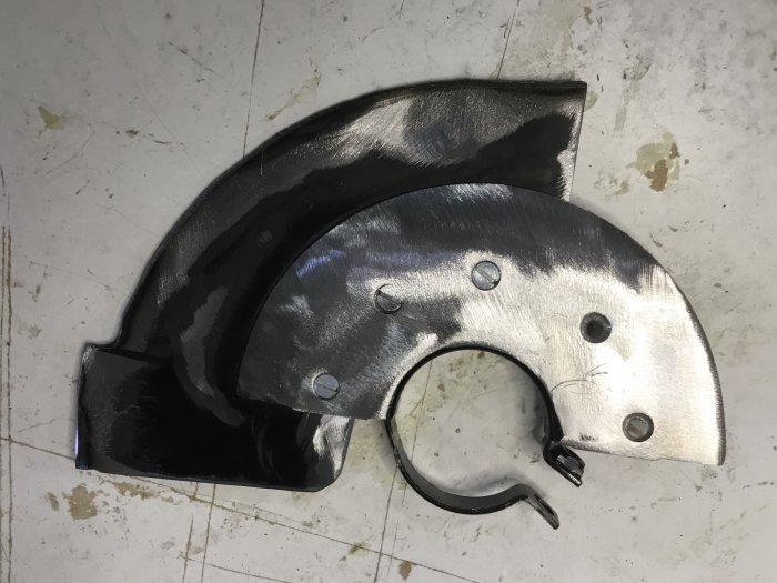 Metallfäste för klyvkniv utsågat från sprängskydd med centrumfäste, bearbetat med vinkelslip.