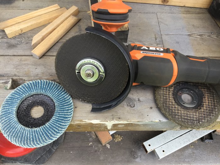 AEG 18v vinkelslip med snabblåsning och olika slip- och kapverktyg på träbänk.