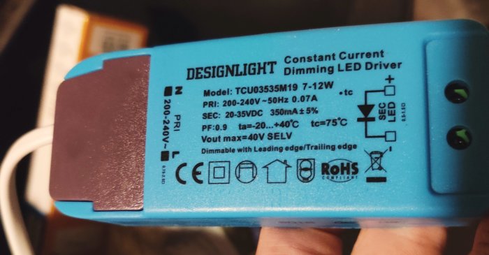 Blå LED-drivare med specifikationsetikett som visar modell, elkrav och säkerhetsikoner.