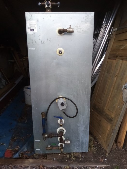 En ackumulatortank från Borö Pannan med röranslutningar och en elpatron, lagrad utomhus.