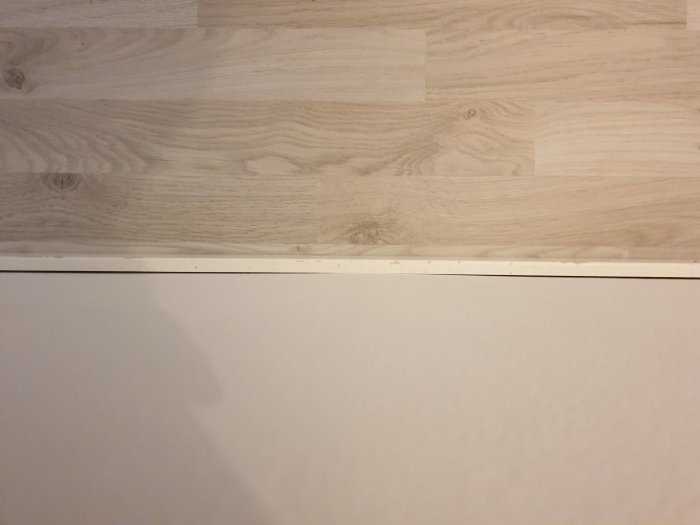 Golvet med synlig list som visar en liten bukning där golvet inte är helt plant.