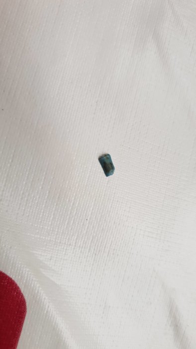 Bit av blå isolering från kopparledning på vit bakgrund utan synliga märken.