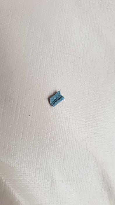Bit av blå isolering på vit yta, inga märken på koppar eller insidan.