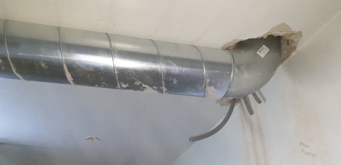 Ventilationsrör som passerar genom vägg med ojämnt hål runt röret.