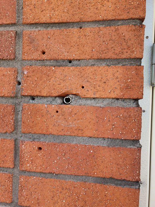 VP-rör genom en tegelvägg som skapar öppningar utifrån, indikation på dålig isolering.