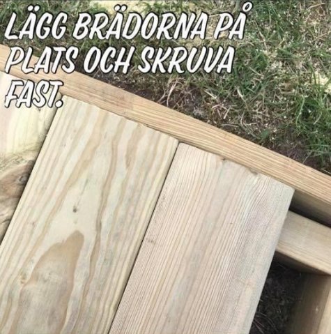 Träreglar med ovanpåliggande trallbräda som potentiellt ska förböjas, gräs i bakgrunden.