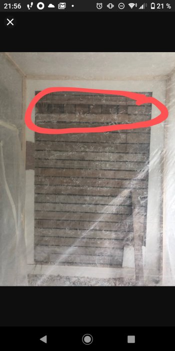 Vägg med träreglar och möjlig synvilla av ändträ markerat med röd cirkel.