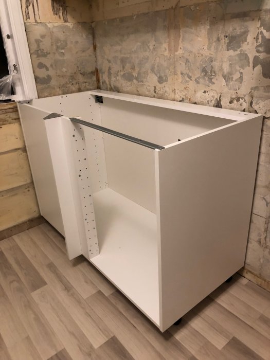 Ny monterad IKEA skåpstomme i ett renoveringsprojekt för kök med oavslutade väggar.