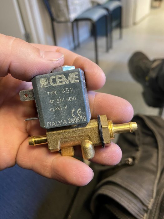 Hand håller en ny ersättningsmagnetventil av märket ACME, avsedd för svetsutrustning.