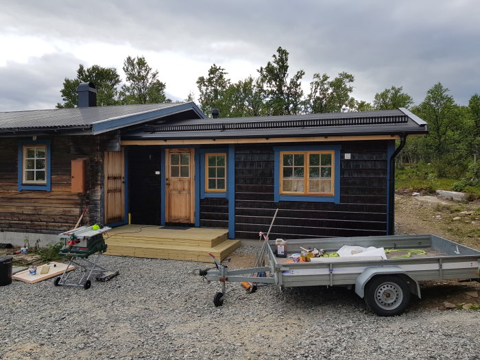 Nyrenoverat hus med uppsatta snörasskydd på taket, ett hus med träfoder och hängrännor redo för vintern.