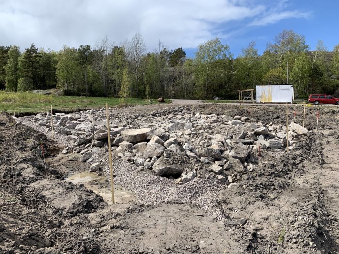 En byggarbetsplats med utlagda stenar och grus i förberedelse för vältning.