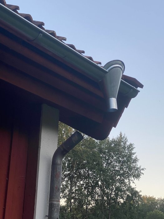 Nyinstallerade handgjorda rännor och vattkupa på ett hus.