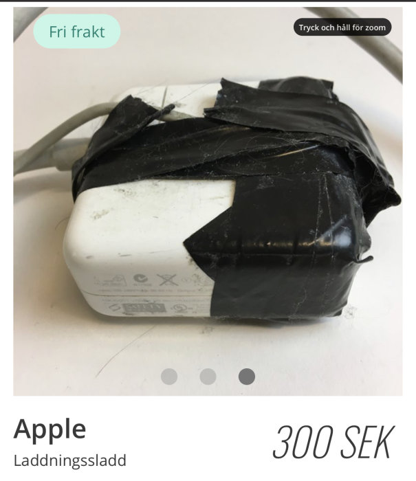 Vit Apple laddningsadapter insvept i svart tejp.