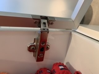 Gångjärn på en vit dörr, användare frågar om justering för bättre stängning.