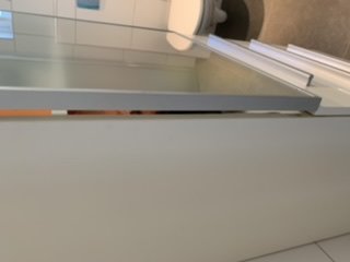 Delvis öppen dörr som inte stänger ordentligt med synligt mellanrum nära gångjärn.