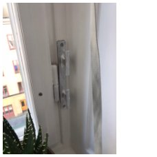 Låsanordning för markis monterad på vit dörrkarm med snöre genom.