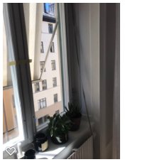 Del av markis med snörelåsningsmekanism i ett fönster med utsikt över byggnader.