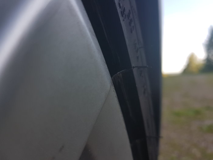 Närbild på bilfälg och däckkant som sticker ut från fälgen, användare orolig för storleksanpassning.
