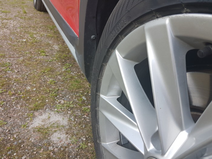 Närbild på bilhjul där däcket ser ut att sticka ut från fälgen.