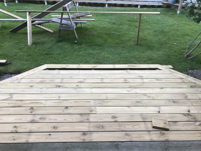 Obehandlad trätrall som är 13 år och nyligen vänd, med en trasig piknikbänk i bakgrunden.