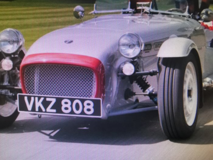 Grå Caterham Super Sprint sportbil i närbild som visar främre stötfångaren, grillen och hjulen.