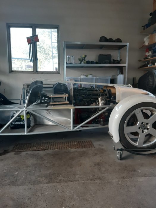 Bild på bilchassi i garage, i linje med instrumentbräda och en del av interiören synlig.