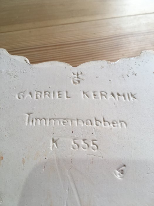 Baksidan av ett kakelplatta med texten "GABRIEL KERAMIK Timmerhåbben K 555" inpräglat.