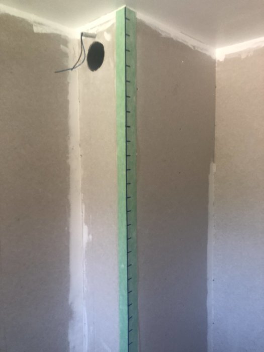 Nyinstallerad bred dörrkarm i ett renoverat badrum med en utstickande elkabel.