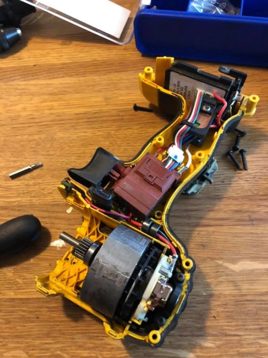 Dewalt DCD780 skruvdragare isärskruvad för byte av kolborstar på ett köksbord.