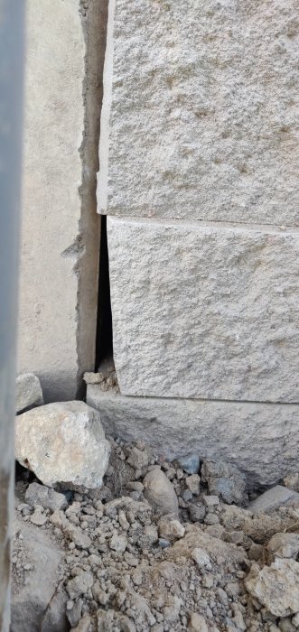 Ojämnt murverk med synliga luckor och ojämna fogar mellan stenblocken.