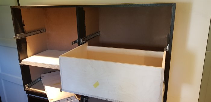 Öppen låda i plywood med synliga skenor i ett halvfärdigt hurtsbygge, behandlad med blandning av tungolja och golvolja.