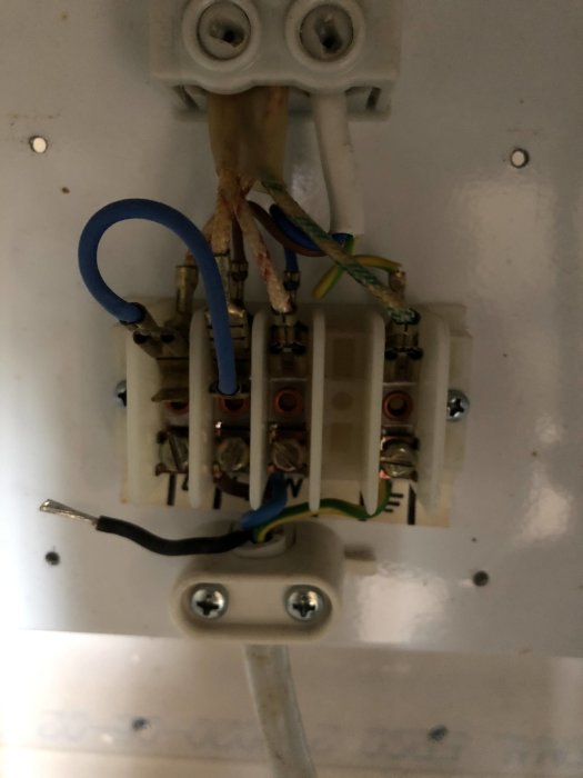 Elkoppling i ett Trinettkök med synliga trådar och anslutningar, en skruvmejsel indikerar att arbetet pågår.