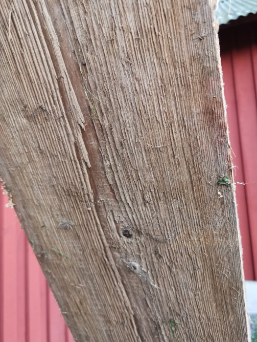 Närvarande bild visar en närbild av ett slitet trägolv med synliga ådringar och märken, möjligen från ett uthus.