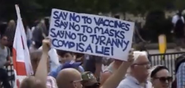 Demonstration med plakat mot vaccin, masker och "tyranni", texten "COVID är en lögn".