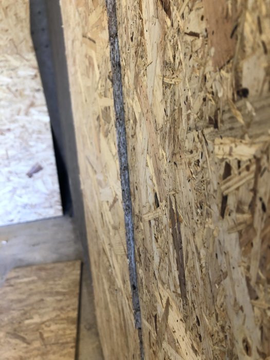 OSB-plater montert på en vegg med synlig skjøt der platene møtes, liten forskjell i dybde mellom platene, som kan skape utfordringer.