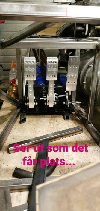 Nya pedaler i en bilmontering som testas för passform i en garageverkstad.